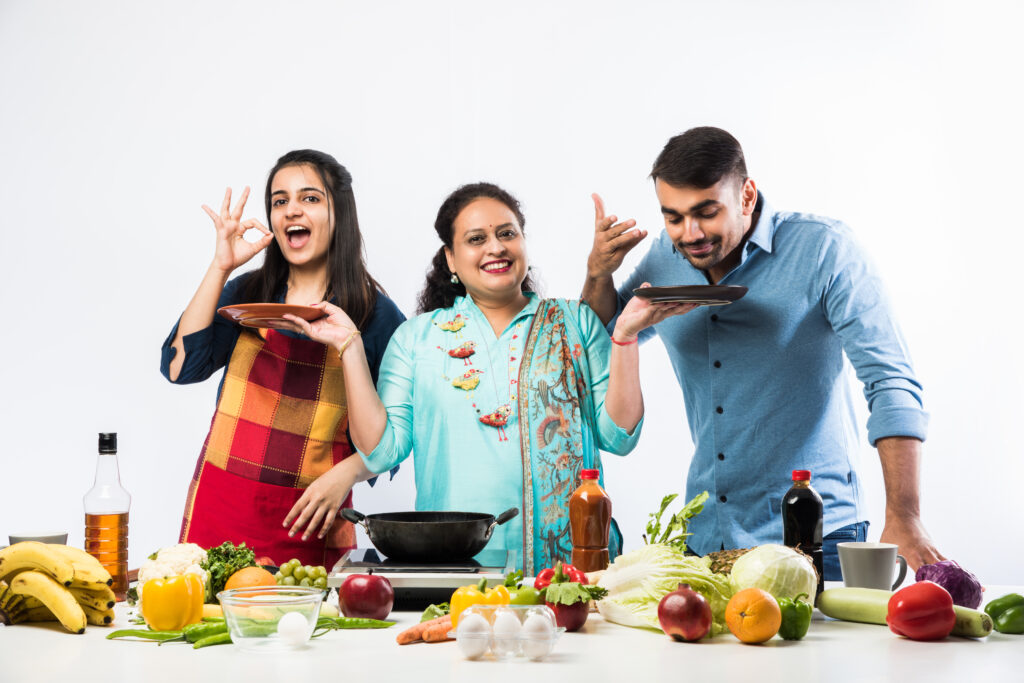 Indian Mother or Sister making food for young kids in kitchen